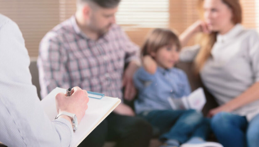 Hand,Of,A,Professional,Family,Psychotherapist,Writing,Notes,In,Front