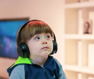 a boy wearing a hoodie listening to music with headphones