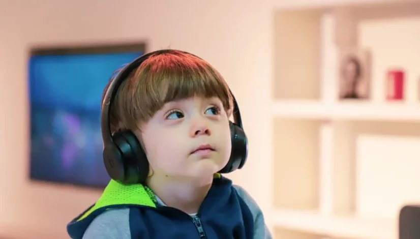 a boy wearing a hoodie listening to music with headphones