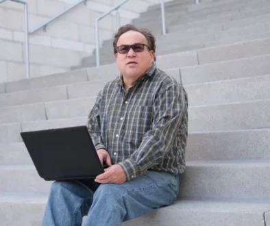 an autistic man holding a laptop