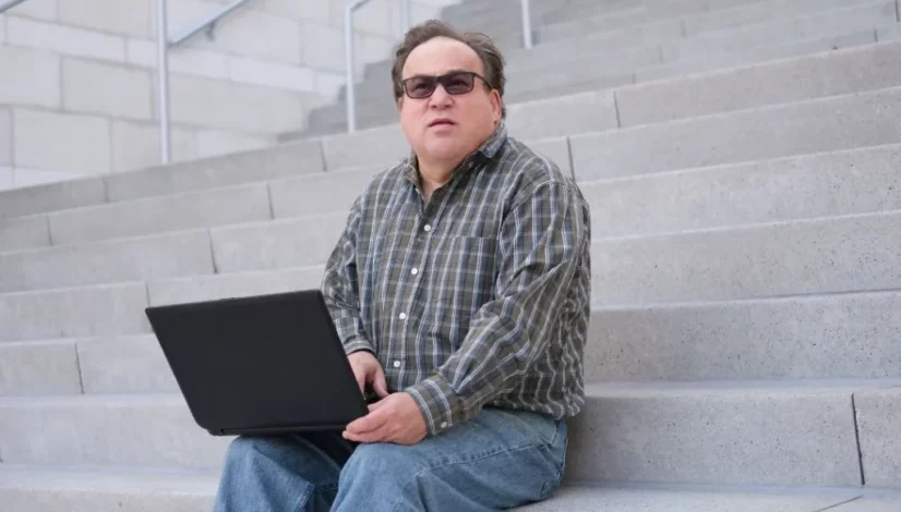 an autistic man holding a laptop