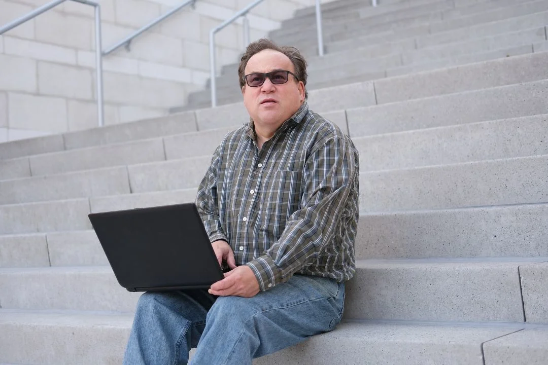 an autistic man holding a laptop