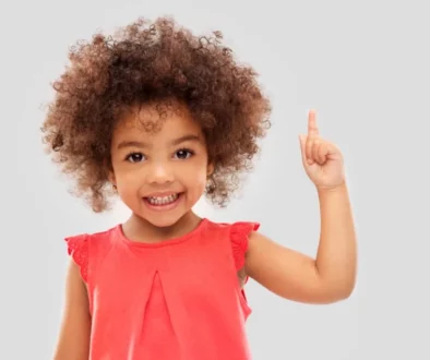 a girl wearing a red dress pointing up