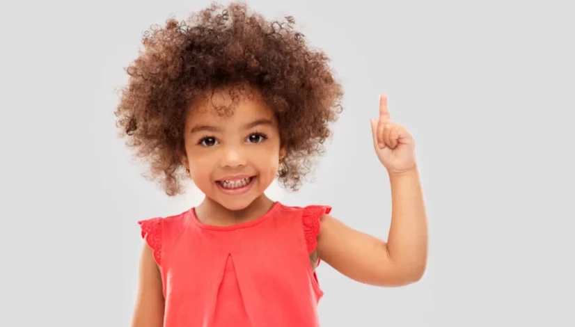 a girl wearing a red dress pointing up