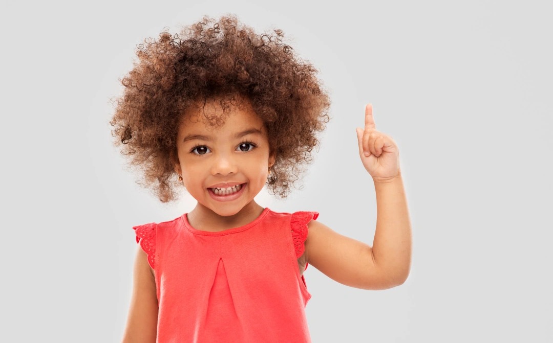 a girl wearing a red dress pointing up